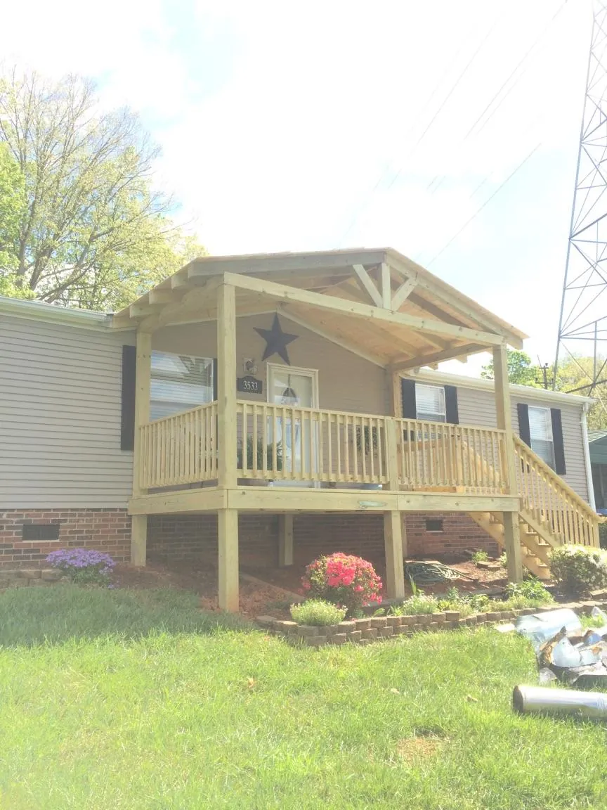 New gabled porch roof and deck railing added to a ranch home in Kingston